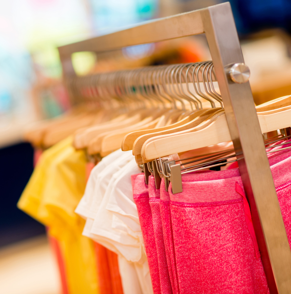 Colorful kids clothes hanging at a retail store on garment racks