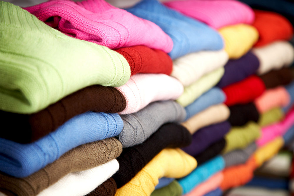colourful clothes stacked in a retail store - woolen jumpers