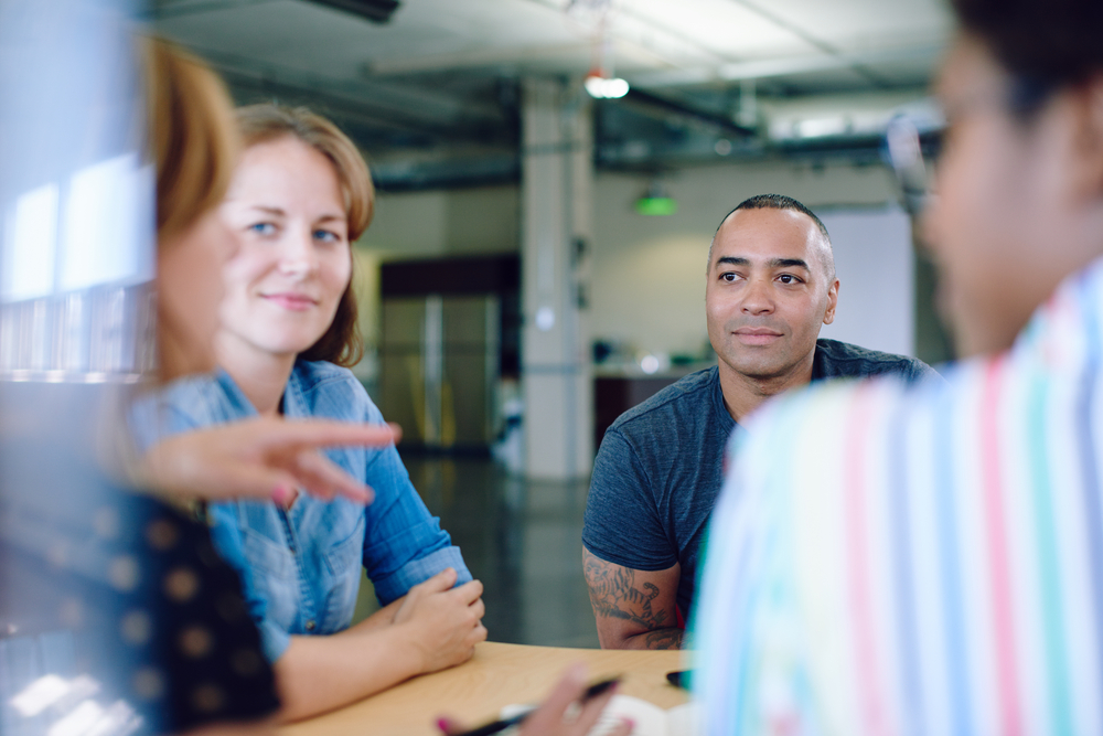 Unposed group of creative business people in an open concept office brainstorming their next project.