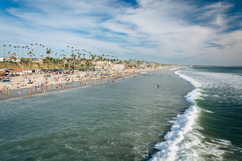 Waves in the Pacific Ocean and view of the beach from the pier in Oceanside, California.